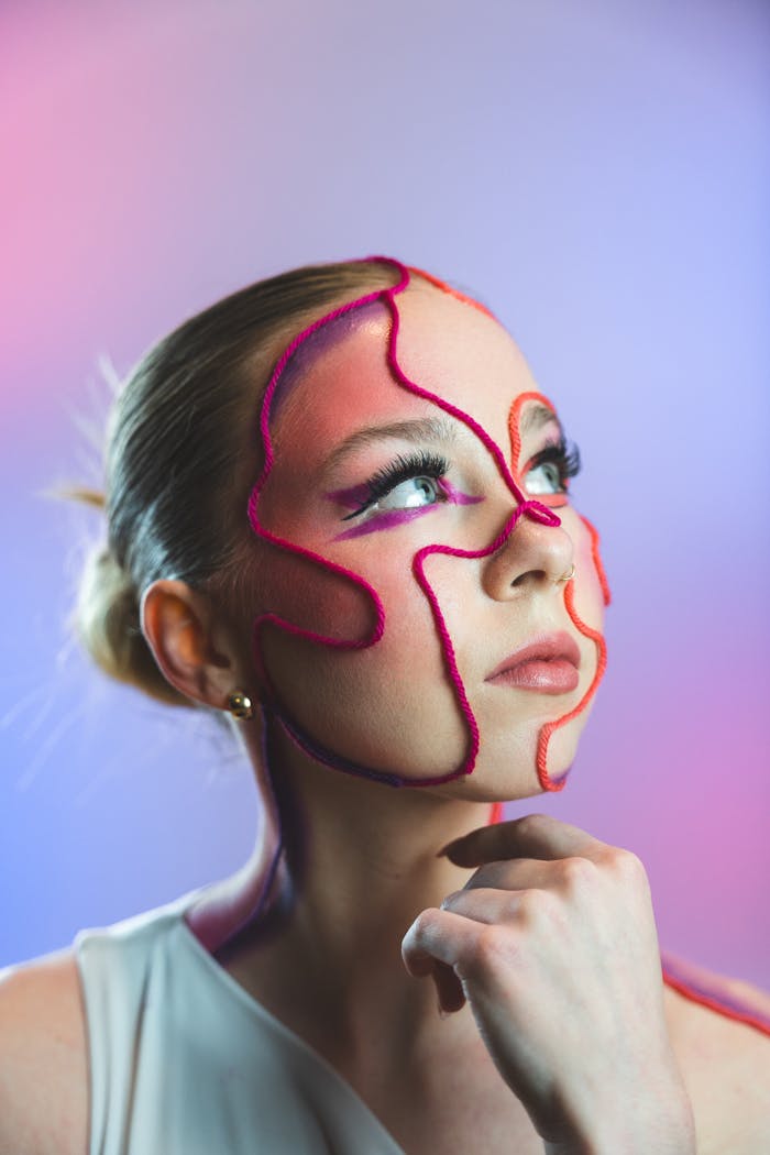 Unique abstract makeup art on a young woman in a studio setting.